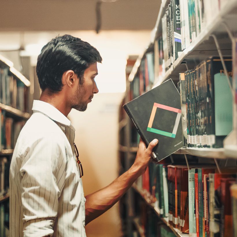 man selecting book